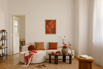 Bright living room with neutral sofa, orange pillows, coffee table with vase of flowers and cozy...