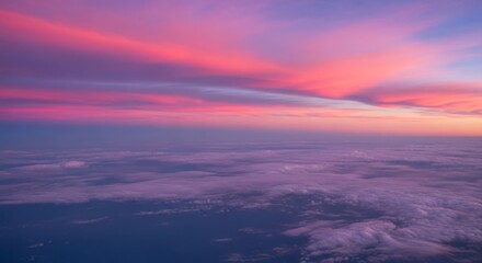 Aerial view of clouds illuminated by a vibrant pink and purple sunset