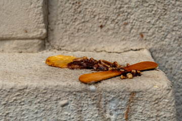 Delicate remnants of a forgotten treat scattered along a weathered stone step in a quiet urban...
