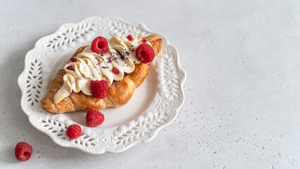 Trendy flat croissant on white plate. Delicious buttery thin croissant with fresh raspberry, cream. french breakfast. Viral Crusty flat croissant recipe, bakery, cafe menu cookbook copy space top view