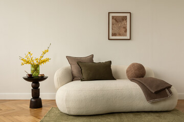 Bright living room with white sofa, green and brown pillows, round cushion and wooden side table with yellow flowers in a glass vase.