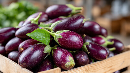 A pile of fresh eggplants in a wooden crate.