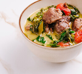 Delicious meat soup with greens served in a bowl during a cozy meal