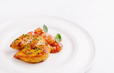 Savory roasted chicken served with fresh cherry tomatoes on a plate
