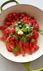 Chopped vine tomatoes bask in olive oil and basil glory, capturing Italian picnic dreams and juicy summer solstice