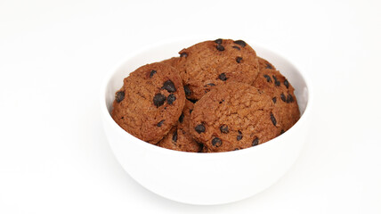 Isolated clipping path of die cut dark chocolate chip cookies on white bowl. Closeup tasty bakery organic homemade American biscuit sweet dessert