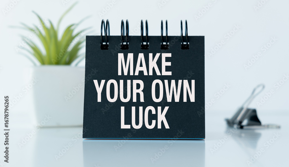 Poster a black notebook with the words make your own luck written on it