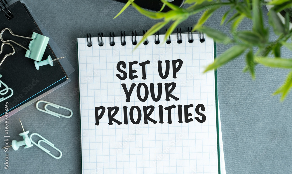 Poster a notebook with the words set up your priorities written on it.