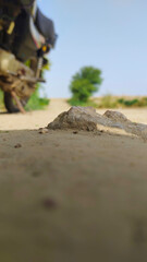 Motorcycle parked near a rugged rock formation in a rural landscape under a bright blue sky offering a sense of adventure and exploration