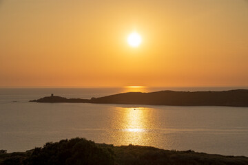 Sun setting over Mediterranean sea with island silhouette, France, Corsica, Cargèse, 18 June 2025