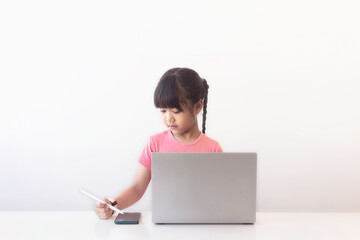 Concept of school, homework, internet and distance learning. Girl doing some activities using...