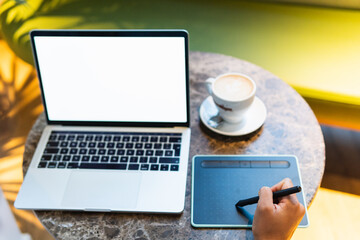 Female graphic designer working on drawing tablet with stylus pen