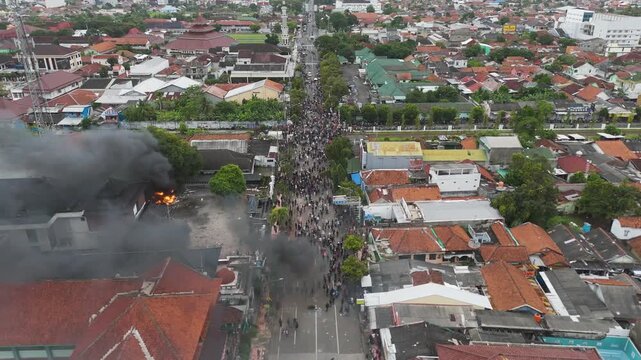 Cilacap, Indonesia- August 30, 2025: Demonstration cilacap protest march unfolds with smoke and burning buildings indonesias unrest.