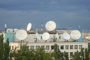 Roof of a house with satellite dishes.

Satellite communication antennas.
