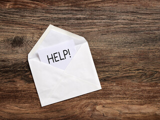 White envelope with help message on wooden table