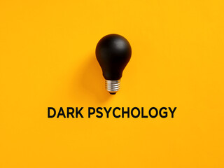 Dark psychology concept with black lightbulb on yellow background