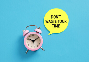 Pink alarm clock and speech bubble saying don't waste your time