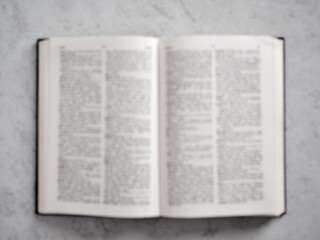 Obraz premium Open Book Lying on Marble Table Showing Text in Blur