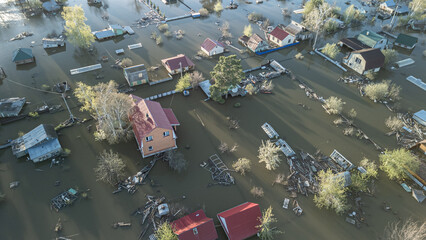 Aerial drone footage showing severe flooding with submerged houses and roads. Wide overhead view of a disaster zone after heavy rainfall, showcasing water damage, extreme weather, and climate-related 