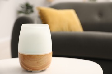 Modern aroma lamp on white table indoors. Space for text