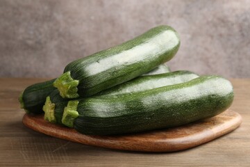Fresh ripe zucchinis on wooden table, closeup
