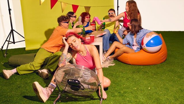 Group of friends sitting on grass with pizza and drinks enjoying summer party mood. Concept of food and beverage sharing, social lifestyle, and carefree outdoor youth culture.