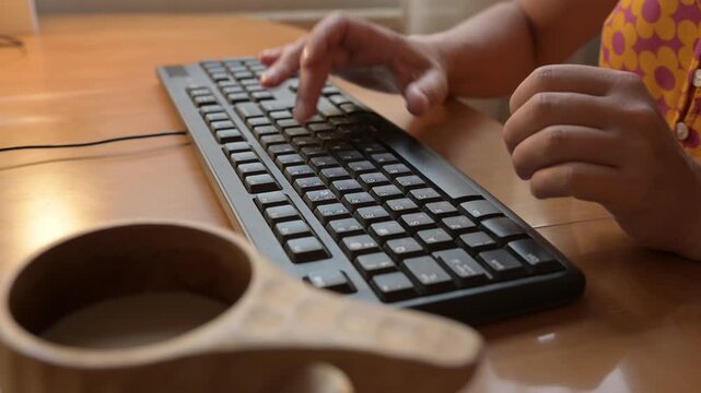 Close-up of hands typing on a black computer keyboard with Cyrillic letters. Person works or studies at desk, concept of technology, communication, office, remote work, and digital lifestyle