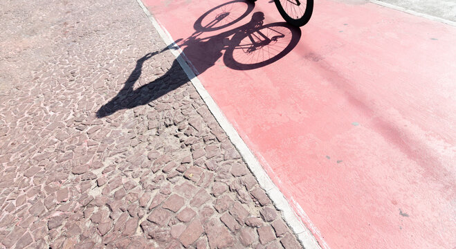 Shadow of a bicycle projected onto a cycle path. Person exercising. Cyclist in action. Lifestyle, - Powered by Adobe