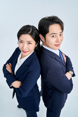 Confident Asian Male and Female Business Professionals Standing Back to Back with Arms Crossed