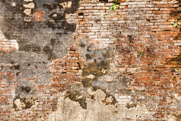 Close-up of old weathered brick wall with peeling plaster and moss in Hue Imperial City Vietnam