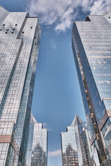 Modern glass skyscrapers reflecting blue sky and clouds