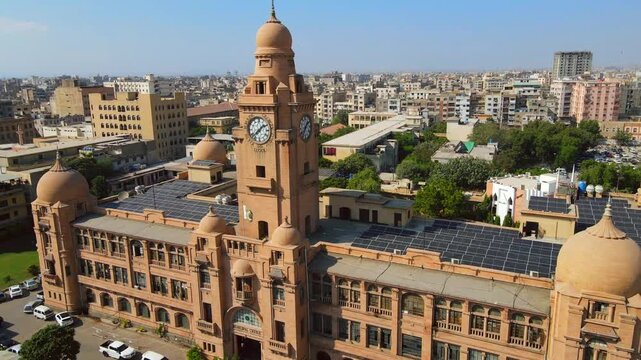 Aerial view of the grand KMC Building featuring a clock tower, its terracotta facade contrasting against the cityscape, Karachi, Sindh, Pakistan.
