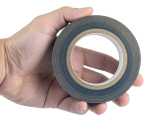 A hand holding a roll of black adhesive duct tape with a visible cardboard core.
