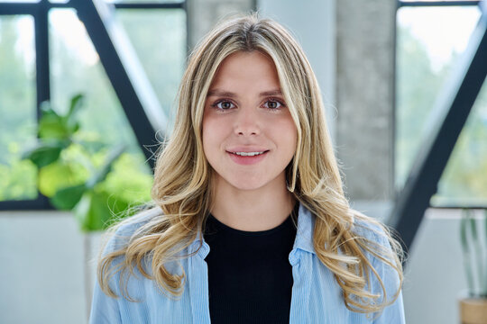 Headshot portrait of young happy woman posing in home