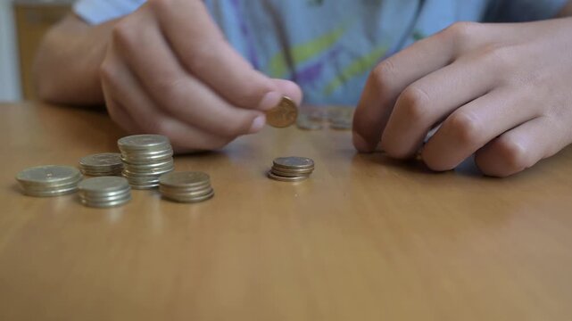 Hands counting Bulgarian lev coins on a wooden table. Concept of finance, savings, economy, money management, currency, budgeting, and daily expenses in Bulgaria