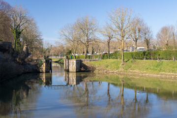 Reflections of the ramparts and trees in Bergues, northern France