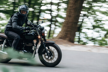 Speed conception, driving. Man in leather clothes on motorcycle is on the road