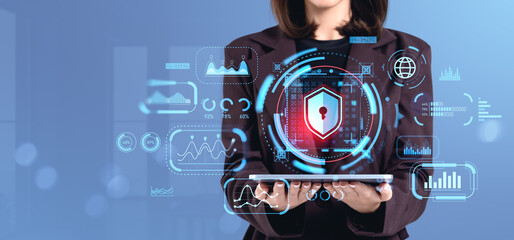 Businesswoman holding tablet with cybersecurity interface graphi