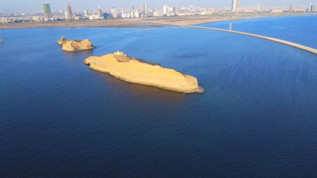 Aerial view of Bundal Island and Sandspit with a long walkway amidst deep blue waters contrasting with the golden sands of the islands, Karachi, Sindh, Pakistan.