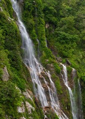 Waterfall cascading down lush green cliff