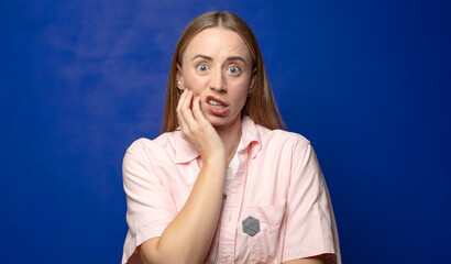 open-mouthed in shock and disbelief, with hand on cheek and arm crossed, feeling stupefied and...