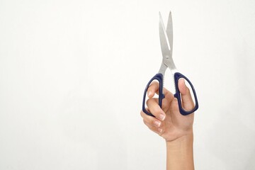 Female hands holding black scissors Isolated on white background. Closeup.