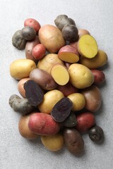 Different types of potatoes on grey table, flat lay