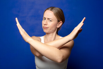 blonde woman looking annoyed and sick of your attitude, saying enough! hands crossed up front,...