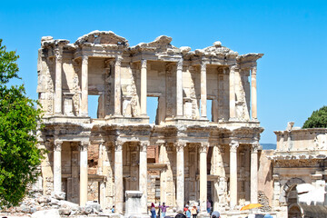 Obraz premium Library of Celsus ruins in Ephesus or Efes Ancient City. Library of Celsus and visitors. The historical building in Izmir, Türkiye is an important touristic excursion area. 