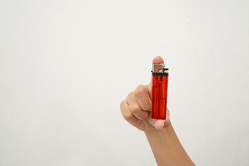woman's hand holding a red gas lighter isolated on a white background