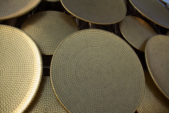Aerial view of a striking arrangement of golden discs gleaming under the sunlight, creating a mesmerizing pattern of circles and shadows, Bommayapalayam, Tamil Nadu, India.