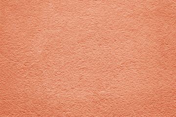 Color of the year 2024 , 13-1023 Peach Fuzz color, plain textured background. Red pink in plaster stucco cement concrete wall pattern texture backdrop. front view