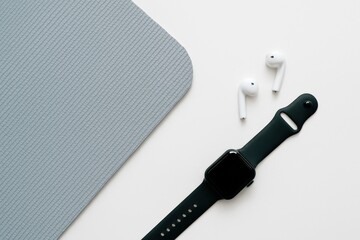 Fototapeta premium Stylish tech accessories on a minimalistic background showcasing a smartwatch and wireless earbuds