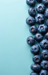 Close-up of fresh blueberries pressed together on a soft blue background. The vibrant blue berries showcase natural texture and juicy details, emphasizing healthy, organic, and raw ingredients.